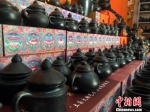 在班玛黑陶公司内，制作好的黑陶整齐的摆放在柜台上供游客们参观。　孙睿 摄 - 文化厅