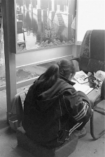 女孩在电话亭写作业。（资料图片） - 浙江网