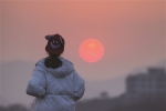 昨天傍晚，一位姑娘戴着小红帽看着夕阳西下。记者 严嘉俊 摄 - 浙江网