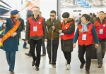 志愿者帮助盲人顾顾登上回老家安徽的火车。 记者 李翔 摄 - 浙江网