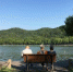 三位游人坐在长椅上欣赏着杭州西湖白堤美景。　徐瀚文　摄 - 浙江新闻网