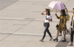 西湖文化广场，行人穿起短袖，撑起了遮阳伞。 记者 朱丹阳 摄 - 浙江新闻网