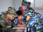 图为：多位小学生与当地武警官兵一起阅读。张新磊 - 浙江新闻网
