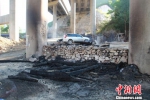 图为因高速电缆燃烧坠落，致桥下村民堆放的木材被烧毁。　于俊亮 摄 - 浙江新闻网