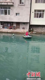 仇云峰乘坐着皮划艇在河面打捞垃圾 仇云峰提供 - 浙江新闻网