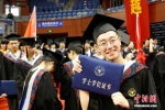 一位毕业生在展示刚刚拿到的学位证书。 中新社记者 王远 摄 - 浙江新闻网
