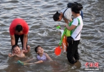 7月4日傍晚，市民们带着小孩在海边戏水消暑。张斌 摄 - 浙江新闻网