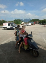 图为：女子骑电瓶车载3名小孩在高速服务区。何蒋勇 - 浙江新闻网