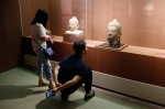 图为：市民正蹲在地上仔细观摩雕塑。王远 - 浙江新闻网