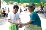 图为：志愿者正把接好的茶水递给一位老年游客。王远 - 浙江新闻网