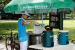 图为：一位志愿者正在往茶桶里加茶水。王远 - 浙江新闻网
