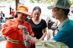 图为：志愿者正把刚接好的茶水递给环卫工人。王远 - 浙江新闻网