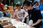 图为：工作人员正在给参加活动的小朋友分蛋糕。王远 摄 - 浙江新闻网