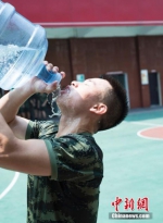 一名士兵抱着水桶豪饮。 潘亮亮 摄 - 浙江新闻网