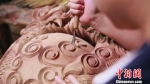 匠人在木鱼上进行精美的雕刻。嵊州宣传部提供 - 浙江新闻网