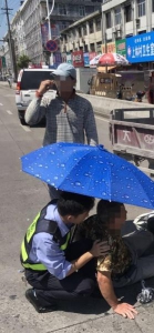 图为：交警跪地为老人撑伞。苍南交警供图 - 浙江新闻网