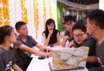 图为伊利集团工作人员参与小学员的创意讨论 - 浙江新闻网