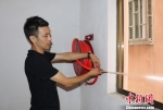 图为：台州玉环一名房东正在检查消防水管。　王刚 摄 - 浙江新闻网