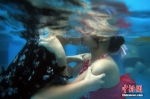 8月19日，一场水下接吻比赛在南京欢乐水魔方水上乐园举行，吸引了不少前来戏水避暑的年轻人跃入水中，憋着气在水中展开火辣辣的接吻耐力大比拼。 泱波 摄 - 浙江新闻网