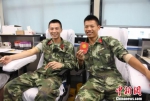 图为：献血官兵展示无偿献血证 刘治乾摄 - 浙江新闻网