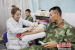 图为：一名护士正在给官兵抽血。　刘治乾 摄 - 浙江新闻网