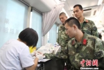 图为：武警官兵们排队等待筛查血样，测试血型。　王刚 摄 - 浙江新闻网