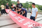 图为：老兵们在横幅上签字。　何蒋勇 摄 - 浙江新闻网