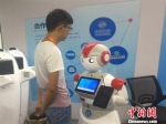 工作人员与服务机器人互动 周禹龙 摄 - 浙江新闻网