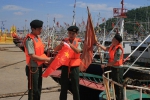 图为：温州边防官兵在苍南舥艚渔港为即将出海的渔船系上崭新的五星红旗。吴金阳（通讯员） - 浙江新闻网
