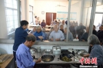 老人们排队领取三菜一汤的套餐 程哲供图 - 浙江新闻网