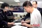 上海警方为美籍逃犯办理遣返手续。　忻文轲　摄 - 浙江新闻网
