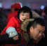 图为2月1日，福州火车站内的一名小朋友看到记者的镜头，露出天真无邪的笑容，小小年纪的她沉浸在过年的新鲜感中，看不到父亲脸上略显疲惫的表情。 王东明 摄 - 浙江新闻网