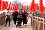 图为：村民们正在挂满红灯笼的小桥上散步。 柱子 摄 - 浙江新闻网