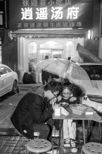 昨天凌晨下着雨，店里坐满了，小王和男友坐在店门口，撑着伞喝胡辣汤。 - 浙江新闻网