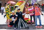 6月12日，位于新疆乌鲁木齐市二道桥的新疆国际大巴扎，游客在硕大的乐器模型前合影。 - 浙江新闻网