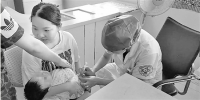 昨日，杭州四季青街道社区卫生服务中心接种点，家长带着宝宝来接种疫苗。 - 浙江新闻网