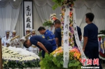 参与吊唁的人员向周锦勇献花并鞠躬致敬。　婷玮 摄 - 浙江网