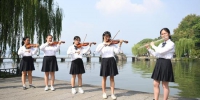 图为：快闪表演者在西湖边进行小提琴演奏。王刚 摄 - 浙江新闻网