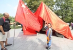图为：一名小朋友向五星红旗敬礼。王刚 摄 - 浙江新闻网