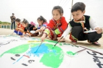 当地苗族、黎族、土家族的十多位少数民族孩子们将垃圾分类等主题绘于长卷。吴拯摄 - 浙江新闻网