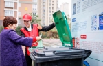物业人员桶边督导居民垃圾分类。温岭供图 - 浙江新闻网