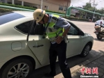 图为：交警循哭声发现车内女孩。　临平中队供图　摄 - 浙江新闻网