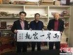 图为斯孝坤（最右）赠家乡“两岸一家亲”书法作品。诸暨台办供图 - 浙江新闻网